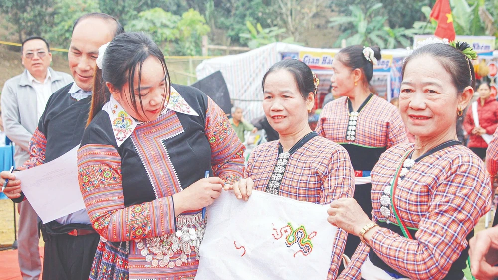 Chấm thi thêu hoa văn trên vải tại Lễ hội Tết cổ truyền dân tộc H'Mông ở xã Chiềng Sại, tỉnh Sơn La. (Ảnh: LÒ THÁI)