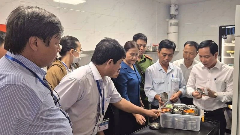 Phó Giám đốc Sở Y tế Tây Ninh Mai Văn Dũng (bìa phải), Trưởng đoàn số 1 của tỉnh kiểm tra, hậu kiểm việc lưu giữ mẫu thực phẩm tại Nhà hàng Buffet Vân Sơn.