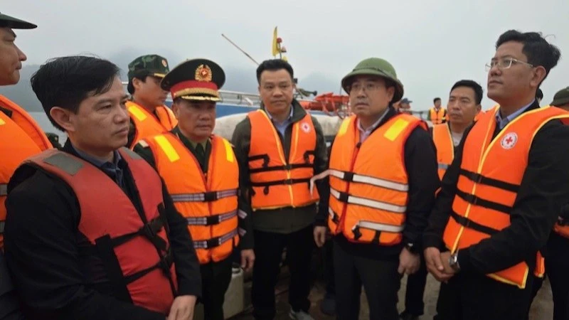 Chủ tịch Ủy ban nhân dân tỉnh Lào Cai Nguyễn Tuấn Anh (người đội mũ, thứ ba từ phải sang) trực tiếp có mặt tại hiện trường, chỉ đạo công tác cứu hộ các nạn nhân bị chìm tàu trên hồ Thác Bà tối 21/2.