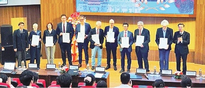 Trao Giấy chứng nhận của Ban tổ chức ghi nhận những đóng góp tích cực của các Giáo sư thuộc Hội Tim mạch Đức-Việt. (Ảnh CÔNG HẬU)