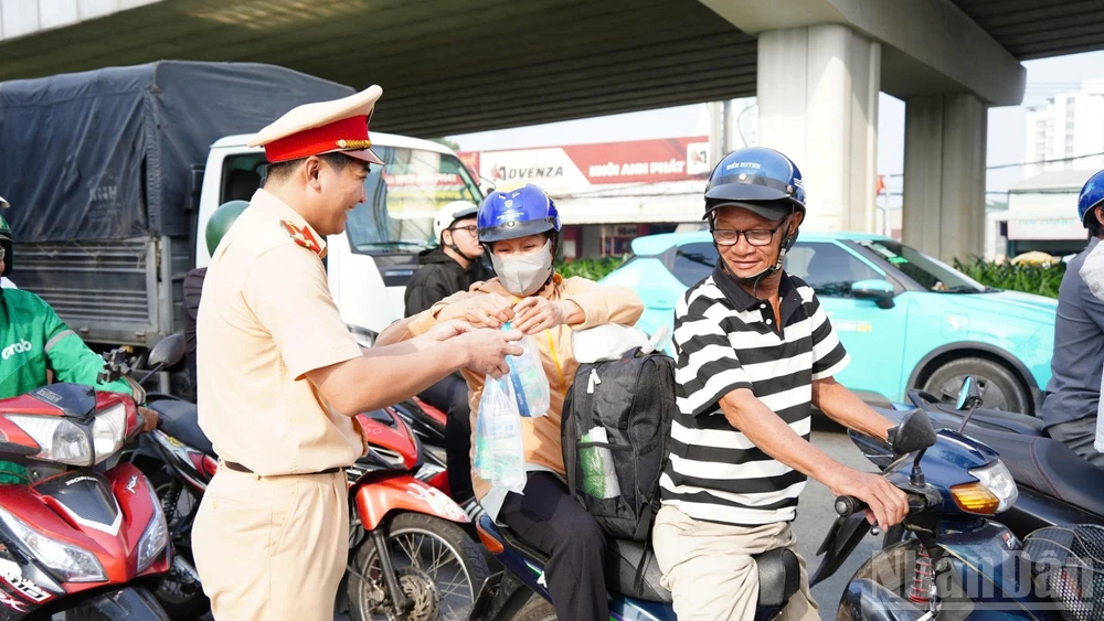 Cảnh sát giao thông Công an tỉnh Đồng Nai phát nước suối, khăn lạnh cho người dân trên Quốc lộ 1A.
