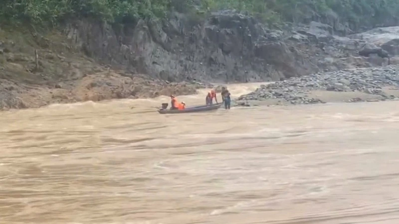 Lực lượng chức năng sử dụng xuồng máy tiếp cận khu vực hai người dân mắc kẹt, đưa họ về bờ. (Ảnh: địa phương cung cấp)