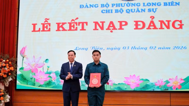 Bí thư Đảng ủy phường Long Biên trao quyết định kết nạp Đảng cho tân binh. (Ảnh: MINH PHÚC)