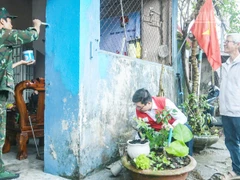 Ông Lê Văn Nam (bên phải) vui mừng khi ngôi nhà được các tình nguyện viên hỗ trợ sơn mới.