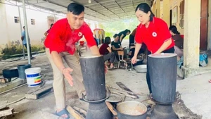Các tình nguyện viên Chữ thập đỏ tham gia nấu cơm hỗ trợ các hộ sơ tán tại Nghệ An. 