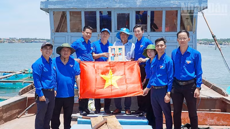 Trao tặng tủ thuốc và cờ Tổ quốc cho ngư dân.