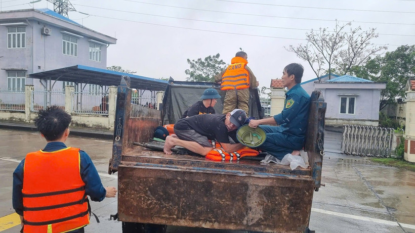 Lực lượng chức năng xã Điện Bàn Tây vận chuyển người bị nạn qua vùng ngập lũ để đi cấp cứu.