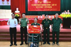 Bộ trưởng Lương Tam Quang tặng xe lăn cho thương bệnh binh nặng.