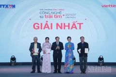 Tổng Giám đốc TTXVN Vũ Việt Trang, Chủ tịch Hội đồng Giải thưởng và Thứ trưởng Bộ Văn hóa, Thể thao và Du lịch Tạ Quang Đông trao giải Nhất cho các tác giả. (Ảnh: THANH GIANG)