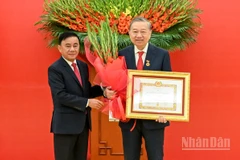 Thường trực Ban Bí thư Trần Cẩm Tú trao huy hiệu 45 năm tuổi đảng, tặng hoa chúc mừng đồng chí Tô Lâm, Tổng Bí thư Ban Chấp hành Trung ương Đảng Cộng sản Việt Nam. (Ảnh: DUY LINH)