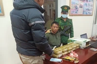Đối tượng Thào A Pháng (người giữa) cùng tang vật khi bị Bộ đội Biên phòng tỉnh Điện Biên bắt giữ. 