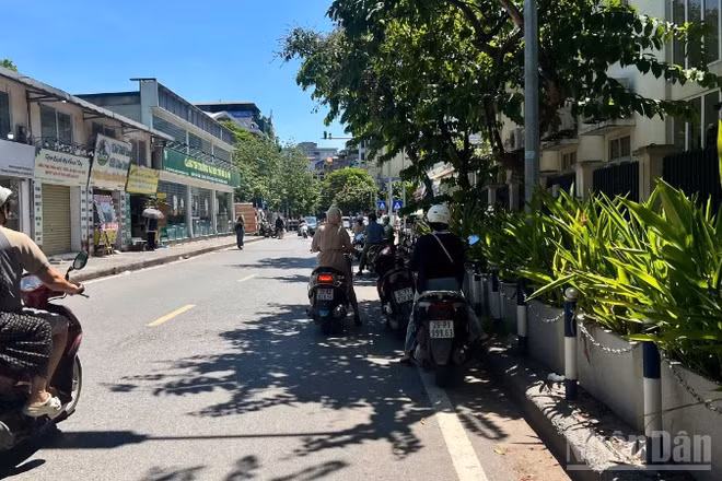 Người dân tận dụng những khoảng bóng râm ít ỏi để tránh nắng trong lúc chờ đèn đỏ. (Ảnh: YẾN PHƯƠNG)