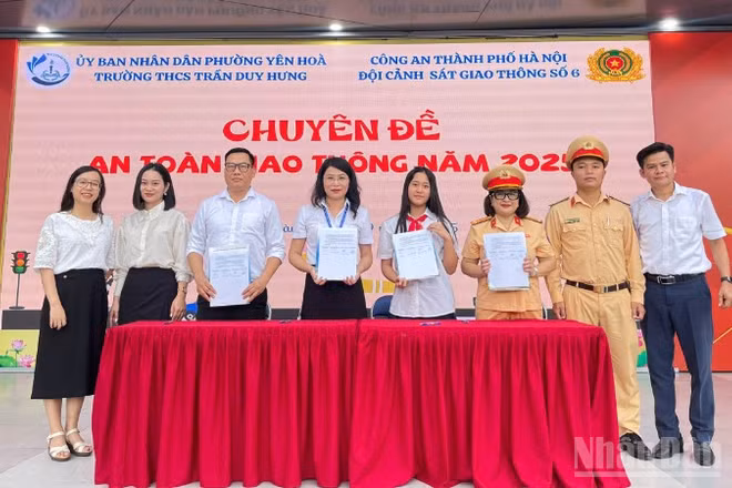 Học sinh, gia đình và nhà trường cam kết cùng hành động vì an toàn giao thông. (Ảnh: PHẠM TRUNG)