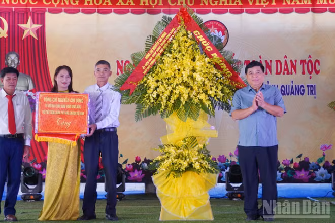 Phó Thủ tướng Chính phủ Nguyễn Chí Dũng tặng hoa chúc mừng cán bộ, nhân dân thôn Liêm Công Tây.