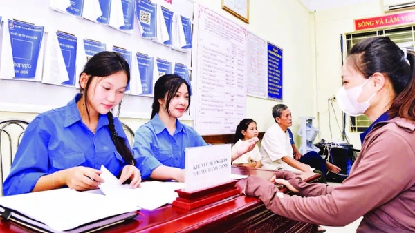 Đoàn viên, thanh niên tình nguyện hỗ trợ người dân xã Minh Châu làm thủ tục hành chính công tại trụ sở xã.