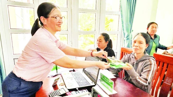 Nhân viên tín dụng Ngân hàng Chính sách xã hội Ninh Phước (Khánh Hòa) giải ngân vốn vay cho người dân đầu tư phát triển kinh tế hộ gia đình.