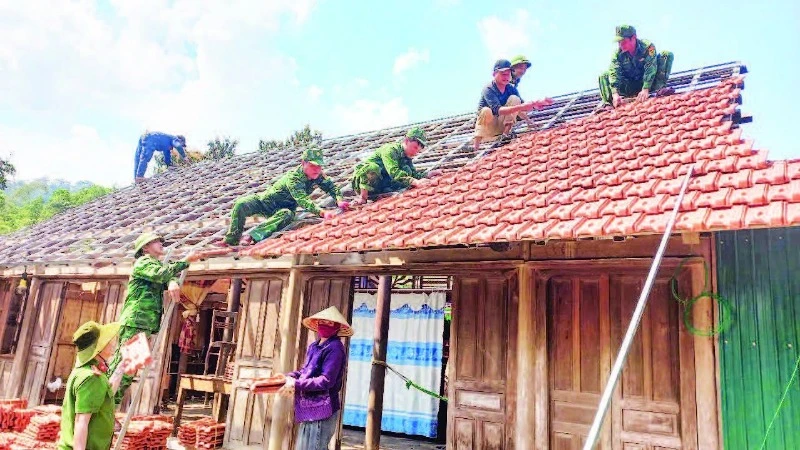 Đoàn viên Bộ đội Biên phòng và Công an tỉnh Quảng Bình tham gia sửa chữa nhà tạm cho hộ nghèo ở xã Thượng Hóa, huyện Minh Hóa.