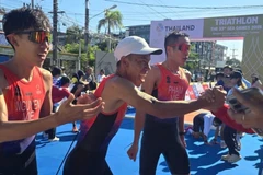 Hoàng Vũ, Anh Trí và Tiến Sản mừng chiến thắng với ban huấn luyện đội tuyển triathlon Việt Nam. (Ảnh: VTF)