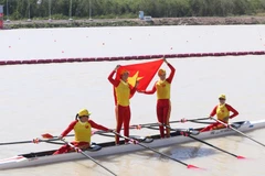 Các tay chèo Việt Nam tự hào giương cao quốc kỳ sau khi cán đích về nhất. 