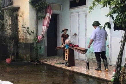 Cán bộ y tế hướng dẫn người dân vệ sinh môi trường để phòng các bệnh truyền nhiễm sau mưa bão tại Hà Nội. (Ảnh: VĂN LẬP)