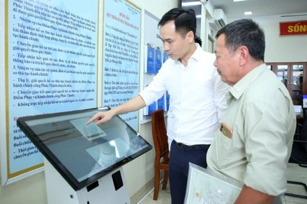 Hướng dẫn người dân thực hiện thủ tục hành chính tại Điểm phục vụ hành chính công xã Phúc Thịnh, thành phố Hà Nội. (Ảnh: NHẬT NAM)
