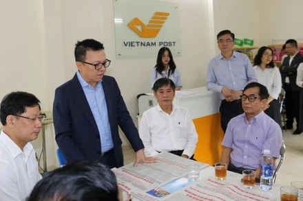 Tổng Biên tập Báo Nhân Dân Lê Quốc Minh trao đổi với người dân địa phương về ý nghĩa của phụ trương công bố dự thảo các văn kiện trình Đại hội XIV do Báo Nhân Dân phát hành.