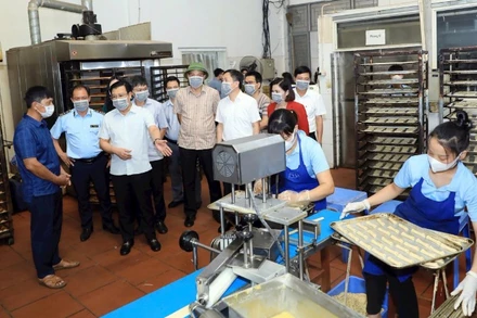 Đoàn khảo sát của Thường trực HĐND thành phố Hà Nội kiểm tra việc chấp hành các quy định của pháp luật về an toàn thực phẩm tại một cơ sở sản xuất bánh kẹo ở xã An Khánh. (Ảnh: LÊ HẢI)