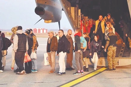 Người dân được sơ tán từ Trung Đông xuống máy bay quân sự khi đến Slovakia. (Ảnh TASR)