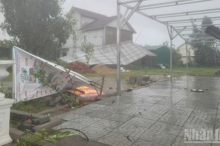 Mái tôn, biển bảng bị gió cuốn nghiêng, đổ ở phường Cửa Lò (Nghệ An). (Ảnh: NGÔ TUẤN)