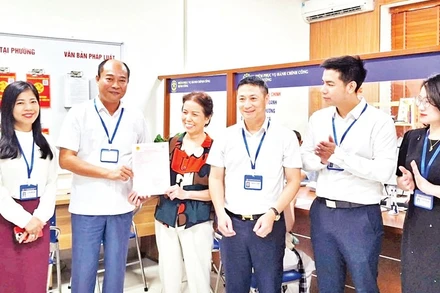 Lãnh đạo phường Định Công trao sổ đỏ cho người dân.