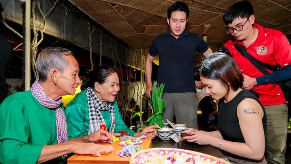 Vợ chồng nghệ nhân Trương Thị Chiều hướng dẫn du khách trải nghiệm làm bánh dân gian.