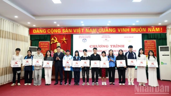Đồng chí Phan Văn Hùng, Phó Tổng Biên tập Báo Nhân Dân và đồng chí Lê Thị Thanh Trà, Phó Chủ tịch Hội đồng nhân dân tỉnh Tuyên Quang trao học bổng cho các sinh viên nghèo vượt khó.