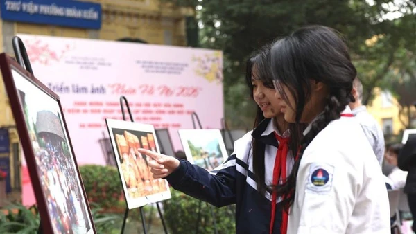 Các em học sinh say sưa ngắm những tác phẩm trong triển lãm.