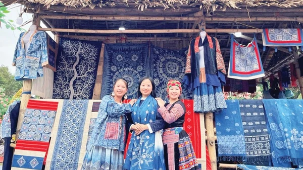 Hàng Y Cô (ngoài cùng bên trái) tại gian hàng thổ cẩm H'Mông của mình.