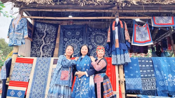 Hàng Y Cô (ngoài cùng bên trái) tại gian hàng thổ cẩm H'Mông của mình.