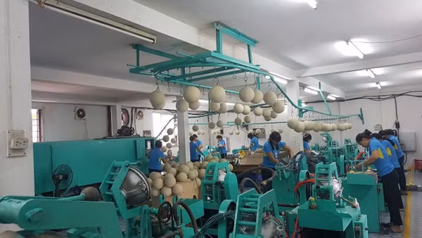 Người lao động với dây chuyền sản xuất bóng thi đấu tại Công ty cổ phần Động Lực. (Ảnh: HOÀI THU)