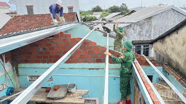 Cán bộ và chiến sĩ Đồn Biên phòng cửa khẩu cảng Dung Quất sửa chữa, xây dựng nhà cho người dân ven biển.