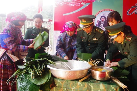 Cán bộ, chiến sĩ Bộ đội Biên phòng và nhân dân tham gia gói bánh chưng đón Tết.