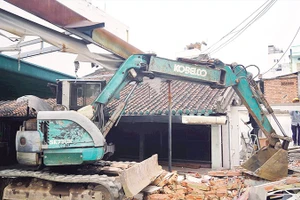 Lực lượng chức năng tháo dỡ công trình xây dựng trái phép tại phường Bình Thạnh. (Ảnh THẾ ANH)