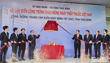 Các đại biểu thực hiện nghi thức gắn biển công trình chào mừng Ngày Thầy thuốc Việt Nam cho tòa nhà CDC Thái Bình.