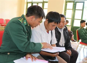 Chiến sĩ Đồn biên phòng Nậm Kè (Bộ đội Biên phòng tỉnh Điện Biên) trao đổi nội dung tuyên truyền, phổ biến pháp luật cho các trưởng bản. (Ảnh: TTXVN)
