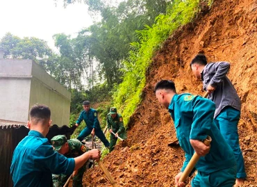 Lực lượng địa bàn trợ giúp hộ dân xử lý điểm sạt lở đất.