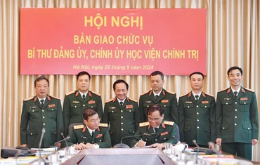 Thượng tướng Trịnh Văn Quyết và các đại biểu chứng kiến Trung tướng Trương Thiên Tô và Thiếu tướng Nguyễn Bá Hùng ký kết biên bản bàn giao. (Ảnh: Báo Quân đội nhân dân)