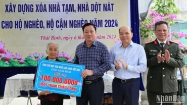 Chủ tịch Ủy ban nhân dân tỉnh Thái Bình Nguyễn Khắc Thận trao biểu trưng hỗ trợ 100 triệu đồng xây nhà mới cho bà Nguyễn Thị Xíu, là hộ nghèo tại xã Tự Tân, huyện Vũ Thư.