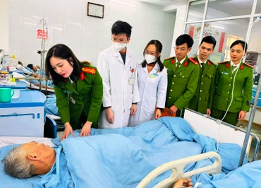 Thành viên đoàn công tác ân cần hỏi thăm sức khỏe bệnh nhân.