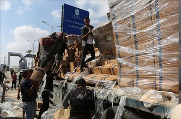 Người dân chuyển hàng cứu trợ nhân đạo tại cửa khẩu Rafah ở Dải Gaza. (Ảnh: THX/TTXVN)