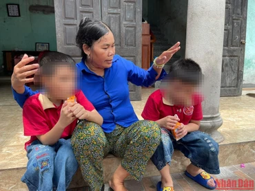 Bà Cúc và 2 người con không chung huyết thống Bảo Q., Bảo K. bên hiên nhà. 