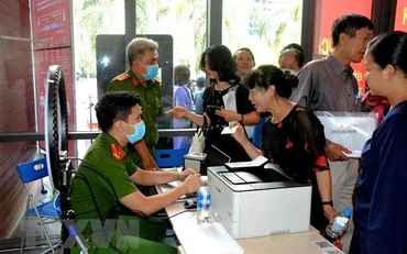 Công an làm căn cước công dân gắn chíp cho người dân tại điểm dịch vụ công trực tuyến. (Ảnh: TTXVN)