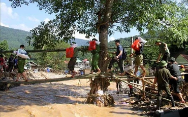 Lực lượng Công an tiếp tế cho người dân bản Hòa Sơn. (Ảnh: TTXVN)