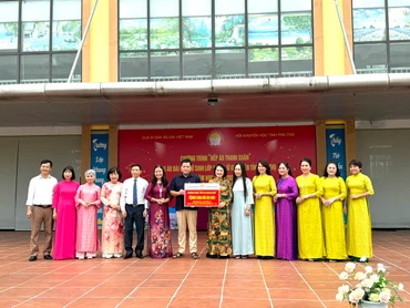 Đại diện Câu lạc bộ Di sản áo dài Việt Nam trao biểu trưng 206 bộ áo dài cho Trường Phổ thông trung học huyện Tân Sơn. (Ảnh: Ban tổ chức)